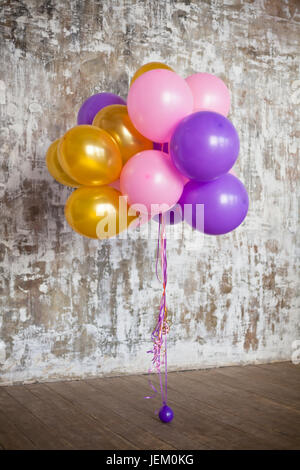 Bouquet de ballons lumineux contre un mur texturé. Copy space Banque D'Images