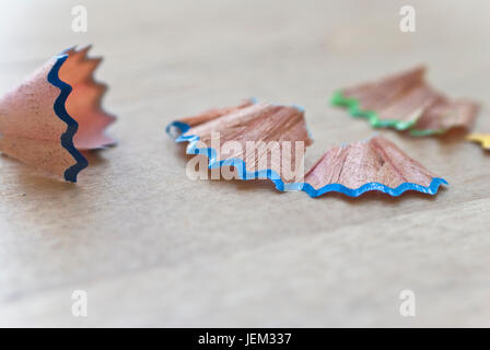 Macro (close-up) de copeaux de bois de couleur crayons art affûtés, éparpillés sur une table en bouleau de la lumière naturelle. Banque D'Images