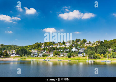 Rurberg village avec des maisons surplombant le Lac Rursee Avec perfect blue sky en été, en Allemagne. Banque D'Images