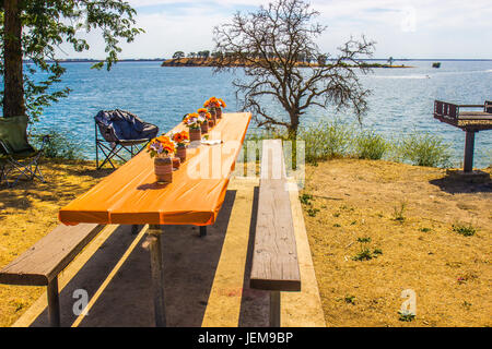 Décoré d'une table de pique-nique et BBQ sur l'île du lac avec en arrière-plan Banque D'Images