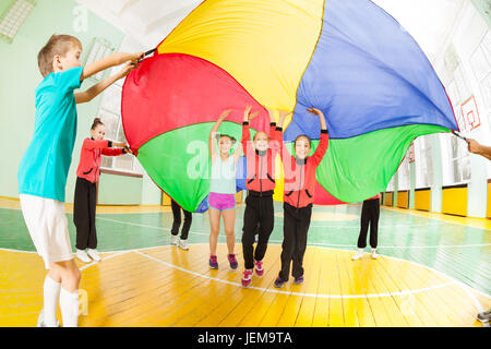 Enfants jouant dans des jeux de parachute sports hall Banque D'Images