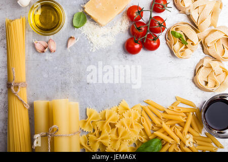 Ingrédients de cuisine italienne traditionnelle et la variété des formes de pâtes sur fond gris clair avec copie espace pour texte, vue d'en haut Banque D'Images