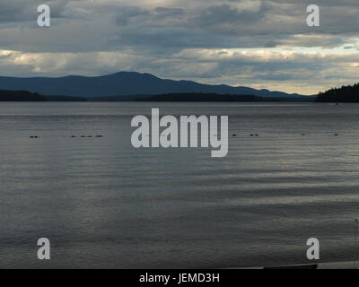 Un beau coucher du soleil brillant à travers les nuages sur le lac Winnipesaukee Banque D'Images