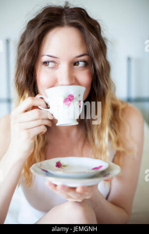 Jeune femme à boire à partir de la tasse Banque D'Images