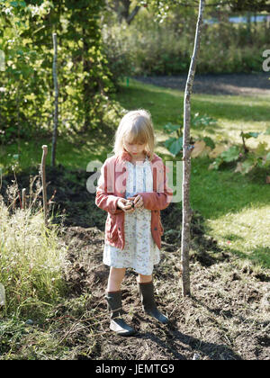 Girl standing in garden Banque D'Images