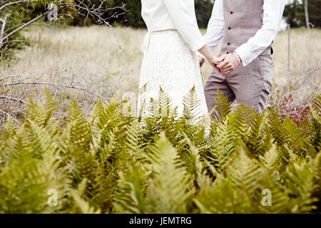 Bride and Groom Holding Hands, mid section Banque D'Images