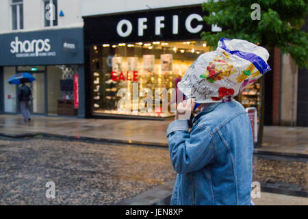 Penwortham, Lancashire, Royaume-Uni. Météo britannique. 27 Juin, 2017. De fortes pluies dans la ville avec unseasonal conditions météo de la district de détail. Des pluies torrentielles font qu'il est difficile pour les acheteurs qui ont du mal avec les fortes rafales de vent et les rafales. La prévision est de poursuivre et de fortes pluies persistantes souvent lentement vers l'Est, avec de forts vents. /AlamyLiveNews MediaWorldImages crédit ; Banque D'Images