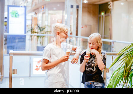 Un garçon et une fille de manger des glaces dans un centre commercial, prise le 16/06/17 à Francfort (modèle) parution dans le monde d'utilisation | Banque D'Images