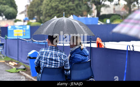 Sussex Eastbourne, Royaume-Uni. 27 Juin, 2017. Les spectateurs à l'abri sous les parasols en pluie arrête de jouer à l'International Aegon tennis Eastbourne tournoi comme un mélange de pluies et d'orages dans le sud-est de la Grande-Bretagne aujourd'hui Crédit : Simon Dack/Alamy Live News Banque D'Images