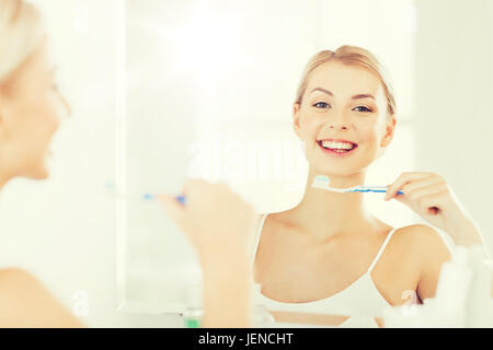 Femme avec les dents au nettoyage de la brosse à dents salle de bains Banque D'Images