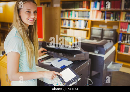 Smiling blonde faisant une copie d'étudiant Banque D'Images