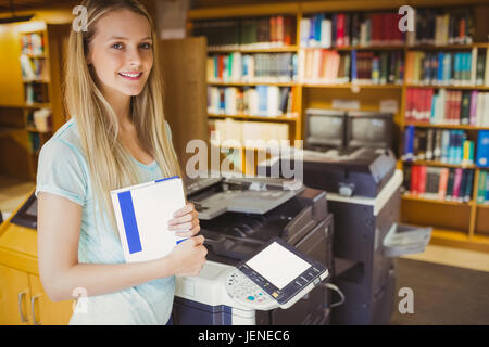 Smiling blonde faisant une copie d'étudiant Banque D'Images