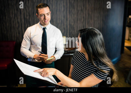 Femme de passer commande pour serveur dans le menu Banque D'Images