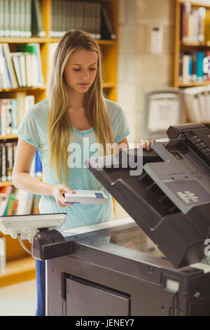 Smiling blonde faisant une copie d'étudiant Banque D'Images
