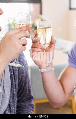 Smiling gay couple toasting with champagne Banque D'Images