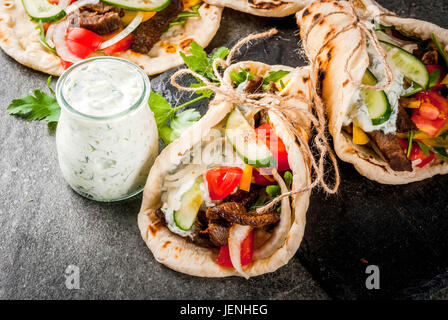 Collation santé, le déjeuner. Sandwich enveloppé traditionnel grec gyros - tortillas, pain pita avec une garniture de légumes, viande de boeuf et de la sauce tzatziki. Sur Banque D'Images