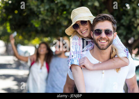 Hip man giving piggy back pour sa petite amie Banque D'Images