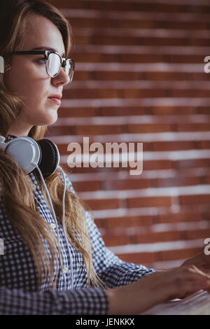 Hipster concentré businesswoman with headphone Banque D'Images