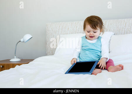 Adorable bébé holding a tablet computer Banque D'Images