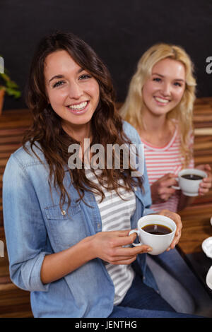 Smiling friends enjoying coffee together Banque D'Images