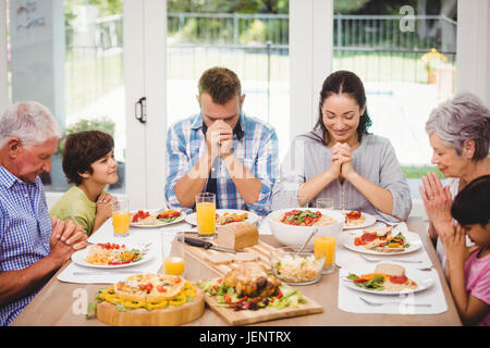 Prier ensemble avant repas de famille Banque D'Images