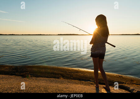 Girl pêche en mer, au crépuscule Banque D'Images