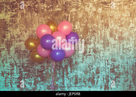 Bouquet de ballons lumineux contre un mur texturé. Copy space Banque D'Images