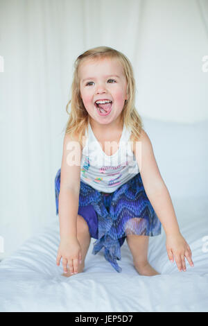 Girl playing on bed Banque D'Images