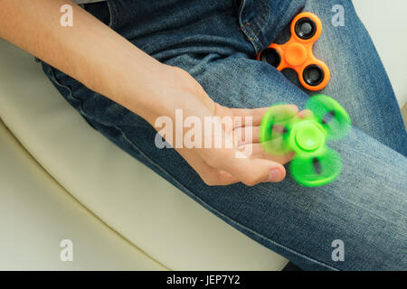 Trendy fidget spinner - personne holding green spinning fidget spinner en main, vue en gros Banque D'Images