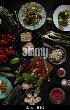 Assortiment de produits frais de la cuisine végétalienne, salade de choux, valériane, tomates, radis, oignons de printemps et noir. brocoli toscan Banque D'Images