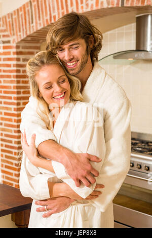 Cute couple cuddling dans peignoirs Banque D'Images