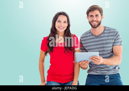 Image composite du couple posing with tablet Banque D'Images