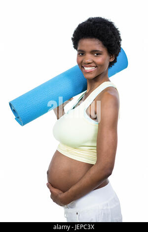 Pregnant woman holding exercise mat Banque D'Images