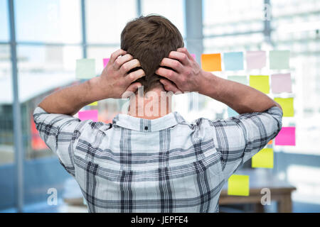 Homme hipster inquiets devant des post-it Banque D'Images