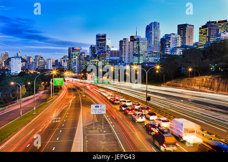 Warringah freeway en passant par North Sydney à Sydney Harbour Bridge au coucher du soleil avec l'heure de pointe au transport lourd comme des lignes de lumières floues Banque D'Images