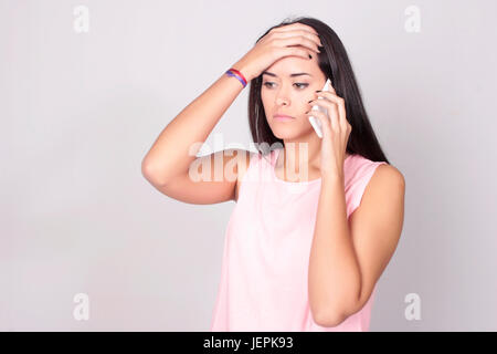 Portrait de jeune femme de race blanche à parler au téléphone, avec l'expression inquiète. Banque D'Images