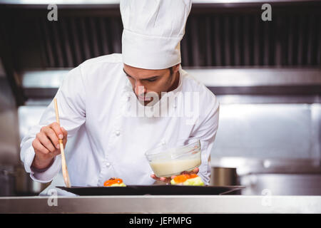 Chef putting sauce sur un plat Banque D'Images