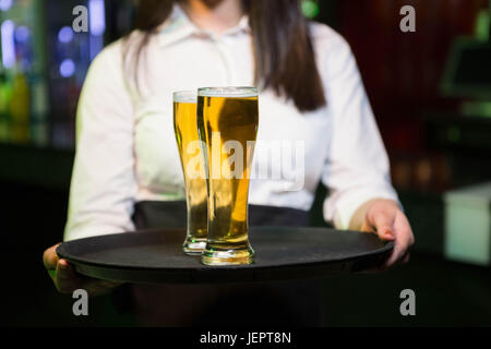 Barman de servir deux verres de bière Banque D'Images