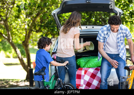 Famille debout devant une voiture Banque D'Images