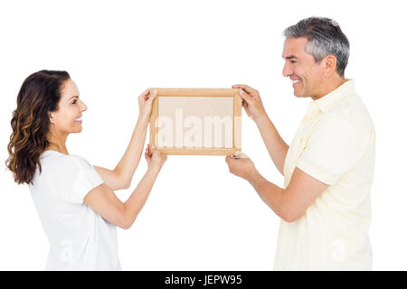 Heureux couple holding photo frame Banque D'Images