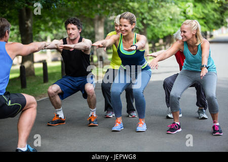 Cours de conditionnement physique faisant séquence squat Banque D'Images