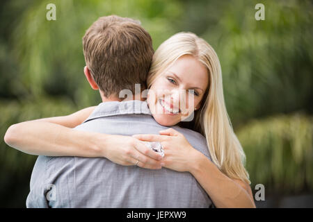 Smiling young woman hugging man Banque D'Images