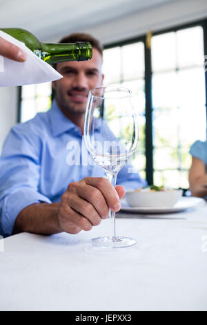 Waiter pouring wine dans un verre de client Banque D'Images