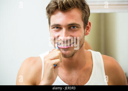 Jeune homme se brosser les dents Banque D'Images