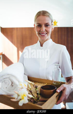 Smiling masseuse holding a tray Banque D'Images