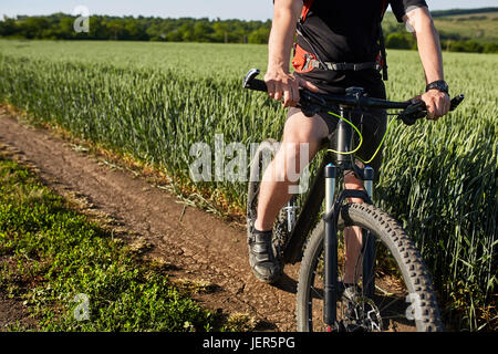 Libre de cycliste homme jambes avec vtt sur piste en plein air dans le domaine de l'été. Banque D'Images