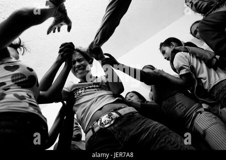 Un garçon, tenue par ses coreligionnaires, des cris de douleur tout en étant supposé posséder par des démons au cours de l'exorcisme rituel effectué à une église de maison à Bogota, Colombie, 28 janvier 2013. Des centaines de Christian belivers, se sont joints à des groupes sans nom, dans le monde d'utilisation | Banque D'Images