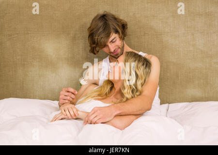 Cute couple cuddling in bed Banque D'Images