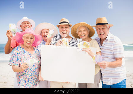 Senior friends holding blank du papier et de l'argent Banque D'Images