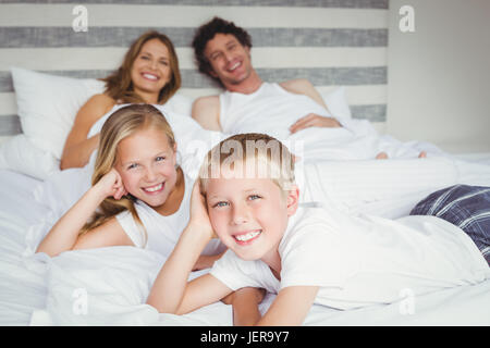 Portrait of happy family resting on bed Banque D'Images